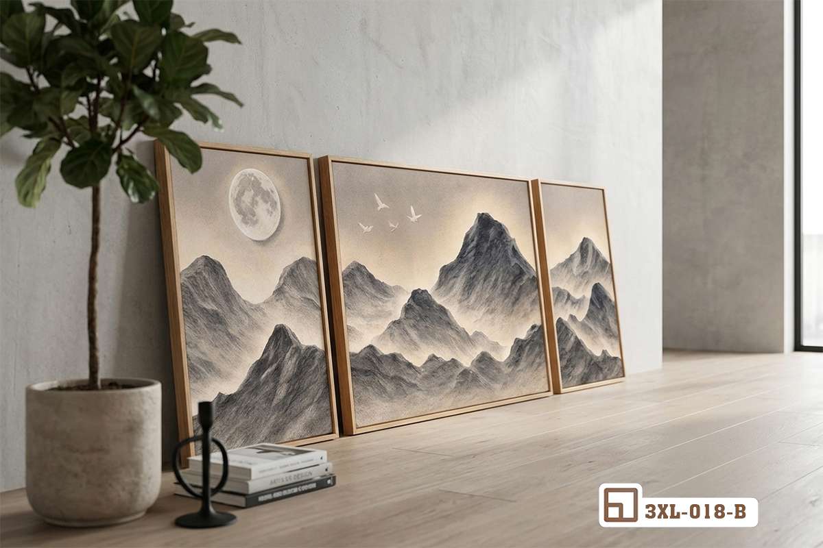 Bộ tranh núi non đơn sắc đặt dựa tường sàn gỗ cạnh chậu cây Ba bức tranh phong cảnh núi non tone xám ghi đặt trên sàn gỗ cạnh chậu cây xanh