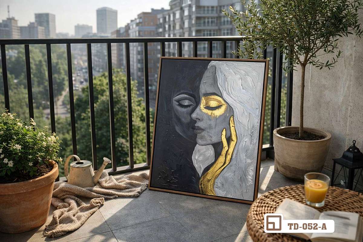 tranh khắc họa ánh kim dựng trên sàn ban công cạnh bàn trà nhỏ và cây xanh ngoài trời Bức tranh khắc họa ánh kim được đặt tựa bên lan can ban công dưới ánh nắng vàng rực rỡ buổi sáng